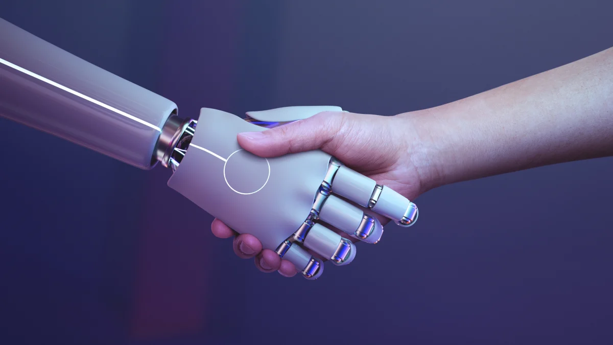 An Image showing handshake between a human and a robot — a symbolic gesture of collaboration between human intelligence and artificial intelligence.